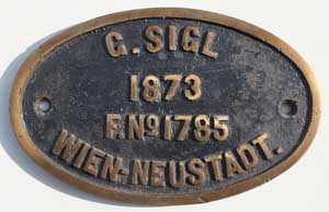 Fabrikschild Sigl, Wien-Neustadt. Fabriknummer: 1785, Baujahr: 1873, Messingguss oval, glatt mit Rand. Das Schild ist von einer C der Oberschlesischen Eisenbahngesellschaft.