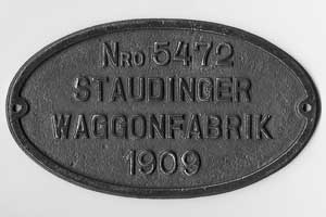 Waggonfabrikschild Staudinger Waggonfabrik (heute Studenka). Fabriknummer: 5472, Baujahr: 1909. Eisenguss oval, glatt mit Rand (GFemR). Das Schild ist von einem Postwaggon der kkstB,  Reihe Fk.