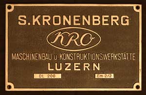 Fabrikschild S. Kronenberg, Luzern: Fabriknummer: 147, Baujahr: 1964. Messingguss, rechteckig, verchromt. Riffelgrund mit Rand. BxH= 250 x 145 mm. Das Schild, beschriftet mit DL 200 ist von der Em 2/2, ex. Feldmhle AG Rorschach, ex. SBB Tm 940. + 2004.