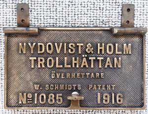 Fabrikschild Nydqvist & Holm, Trollhättan: Fabriknummer: 1085, Baujahr: 1916. Messingguss, rechteckig, Riffelgrund mit Rand. Mit angeschweißten Scharnieren. BxH =  x mm. Das Schild ist von der dänischen Privatbahn HFHJ, Lokomotive No.6.