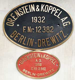 Fabrikschild Orenstein & Koppel A.G., Berlin-Drewitz: Fabriknummer: 12382, Baujahr: 1932. Messingguss, oval, Riffelgrund mit Rand. Zylinderschild: BxH = 350 x 250 mm. Rahmenschild: BxH = 211 x 133 mm. Das Schild ist von der DRG 64 236.
