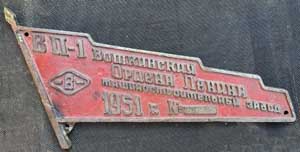 Fabrikschild Votkinsk, Fabriknummer: 899, Baujahr: 1951. Aluminiumguss, Sonderform, glatt mit Rand. Diagonale = 460 mm. Das Schild ist von einer 750mm Schmalspurbahn. Die Maschinenfabrik Votkinsk baute bis 1917 Lokomotiven, dann bis zum Ende des WWII Waffen. Zwischen 1947 und 1960 wurden etwa 2350 Schmalspurlokomotiven der Serie VP -1-4 gebaut. Das ist auf dem Schild vermerkt. Heute ist das Werk einer der wichtigsten Rüstungsbetriebe und baut Raketen für Atomsprengköpfe und die gefürchtete Iskander-Rakete.