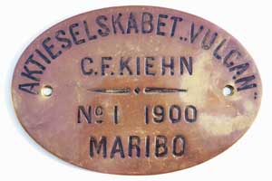 FabrikschildAktieselskabet Vulcan, C.F. Kiehn. Fabriknummer: 1, Baujahr: 1900. Messingguss oval, glatt ohne Rand, Negativguss. Das Schild ist von der 1B-Tenderlok der Odense-Kjerteminde-Dalby Eisenbahn.