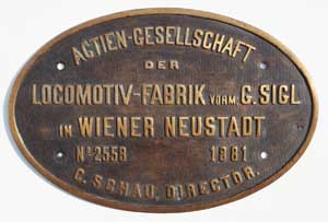 Fabrikschild Actien-Gesellschaft der Locomotiv-Fabrik vorm. G. Sigl in Wiener Neustadt. Fabriknummer: 2559, Baujahr: 1881, Messingguss, oval, Riffelgrund mit Rand. Das Schild ist von einer 1B, nach Portugal. BxH = 407 x 270 mm.