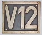 V12 der Mindener Kreisbahn. Aluminium (V+12+Rand), genietet auf einer Pertinaxplatte.